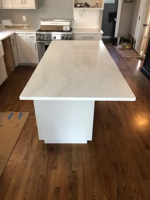 White stone kitchen island with a waterfall edge.