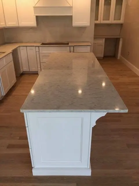 White stone countertop on a finished kitchen island.