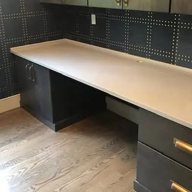 White stone countertop with dark kitchen cabinetry.