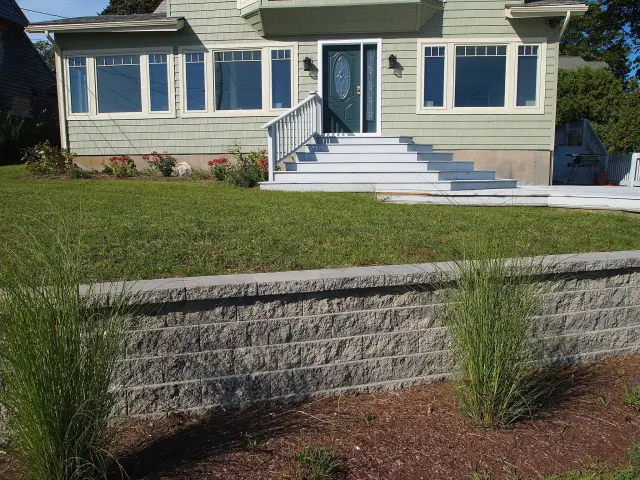 Stone retaining wall in a finished yard.