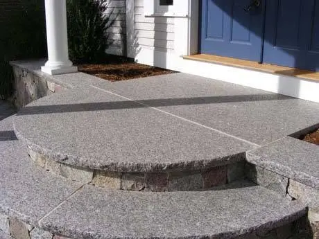 Curved stone retaining wall in a residential landscape.