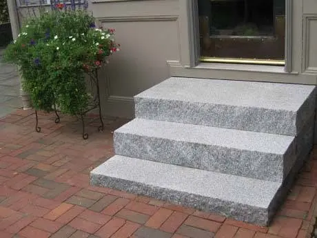Granite porch steps at a finished home entry.
