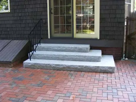 Stone entry steps connected to a paver walkway.
