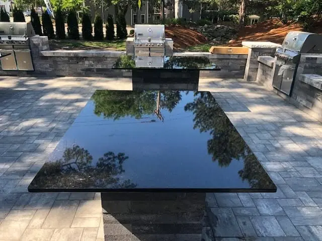 Stone outdoor countertop beside a finished patio.