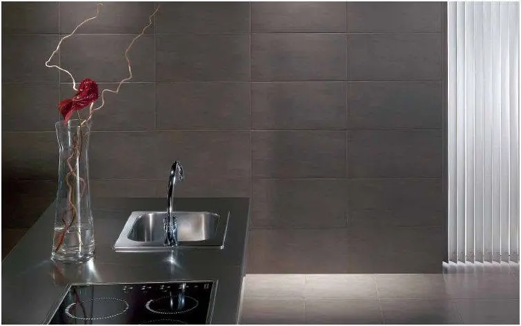 Dark tile backsplash behind a kitchen sink.