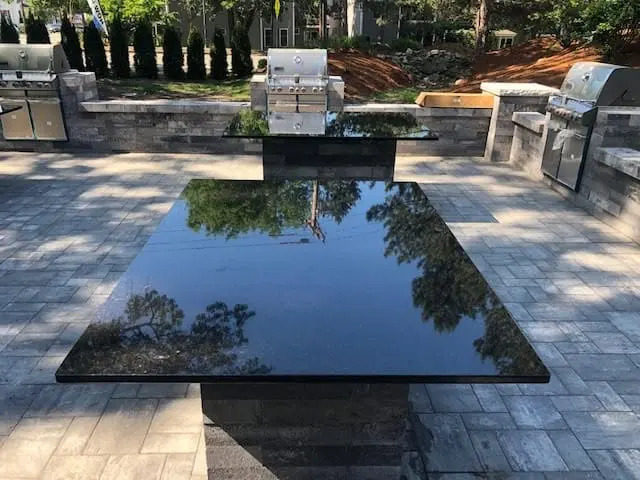 Stone outdoor countertop beside a finished patio.