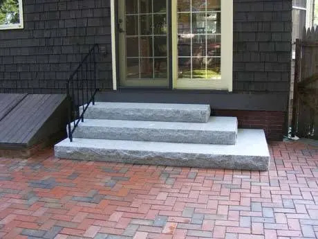Stone entry steps connected to a paver walkway.