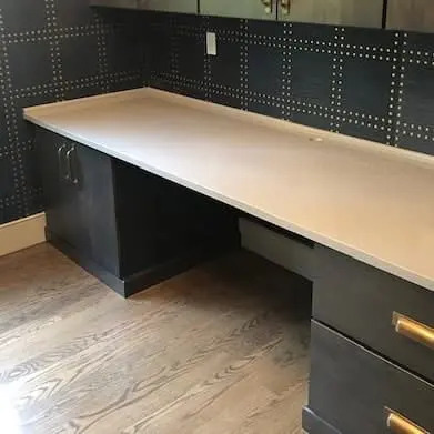 White stone countertop with dark kitchen cabinetry.