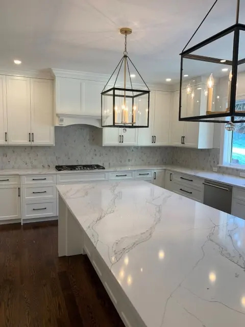 White stone island and countertop in a completed kitchen.